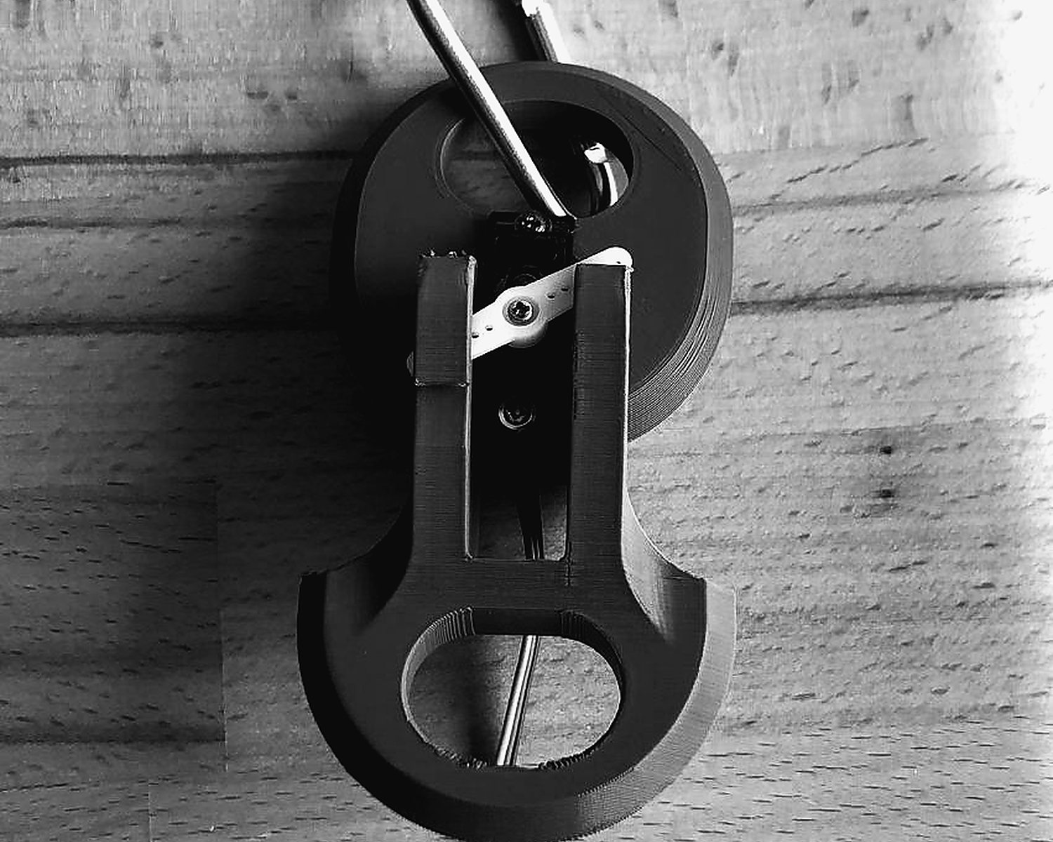 A printed servo quick-release latch with a carabiner, the servo horn visible in the slot