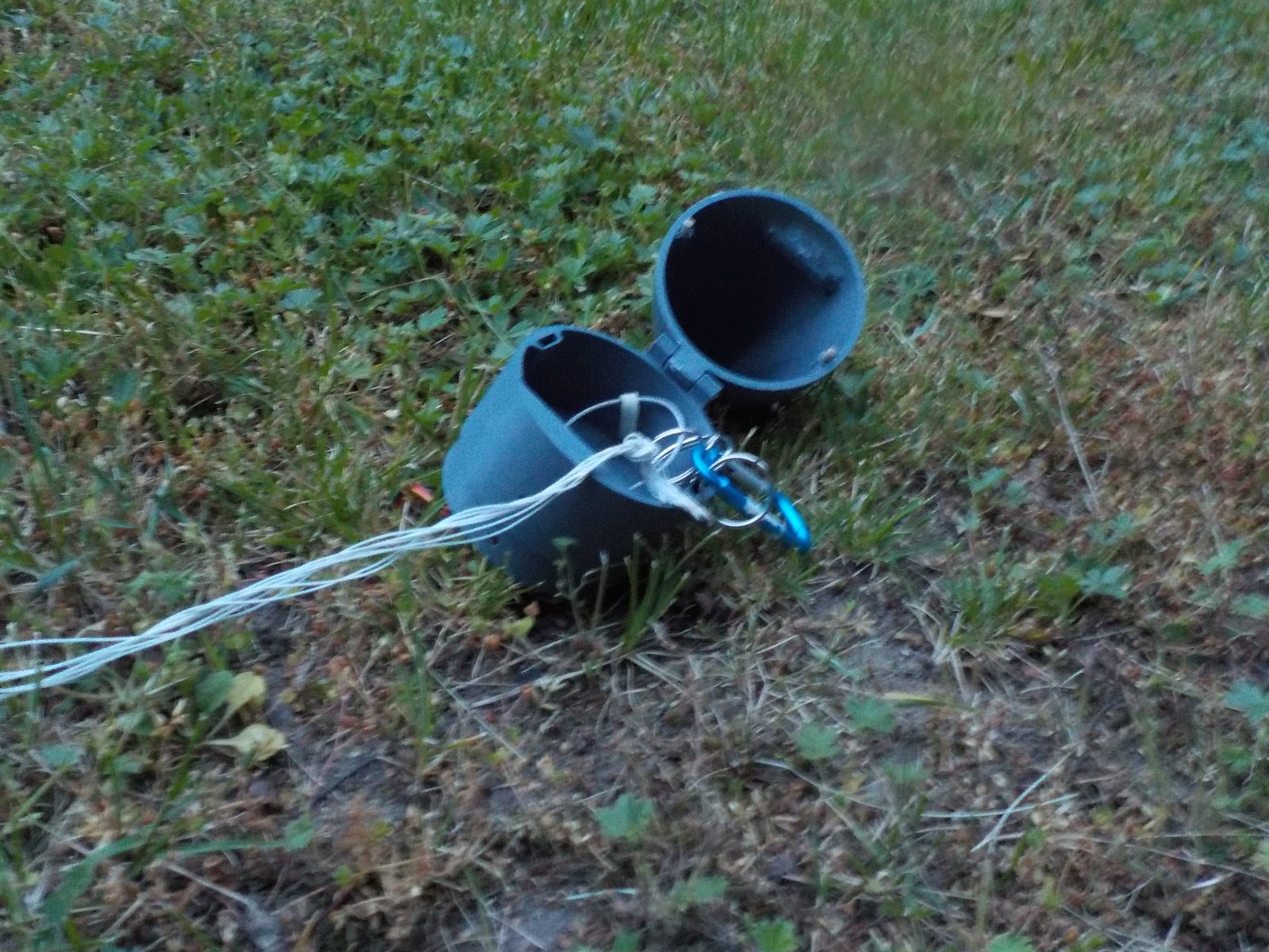 The mk2 recovery section, a printed nose cone and coupler, lying on grass with its cord
