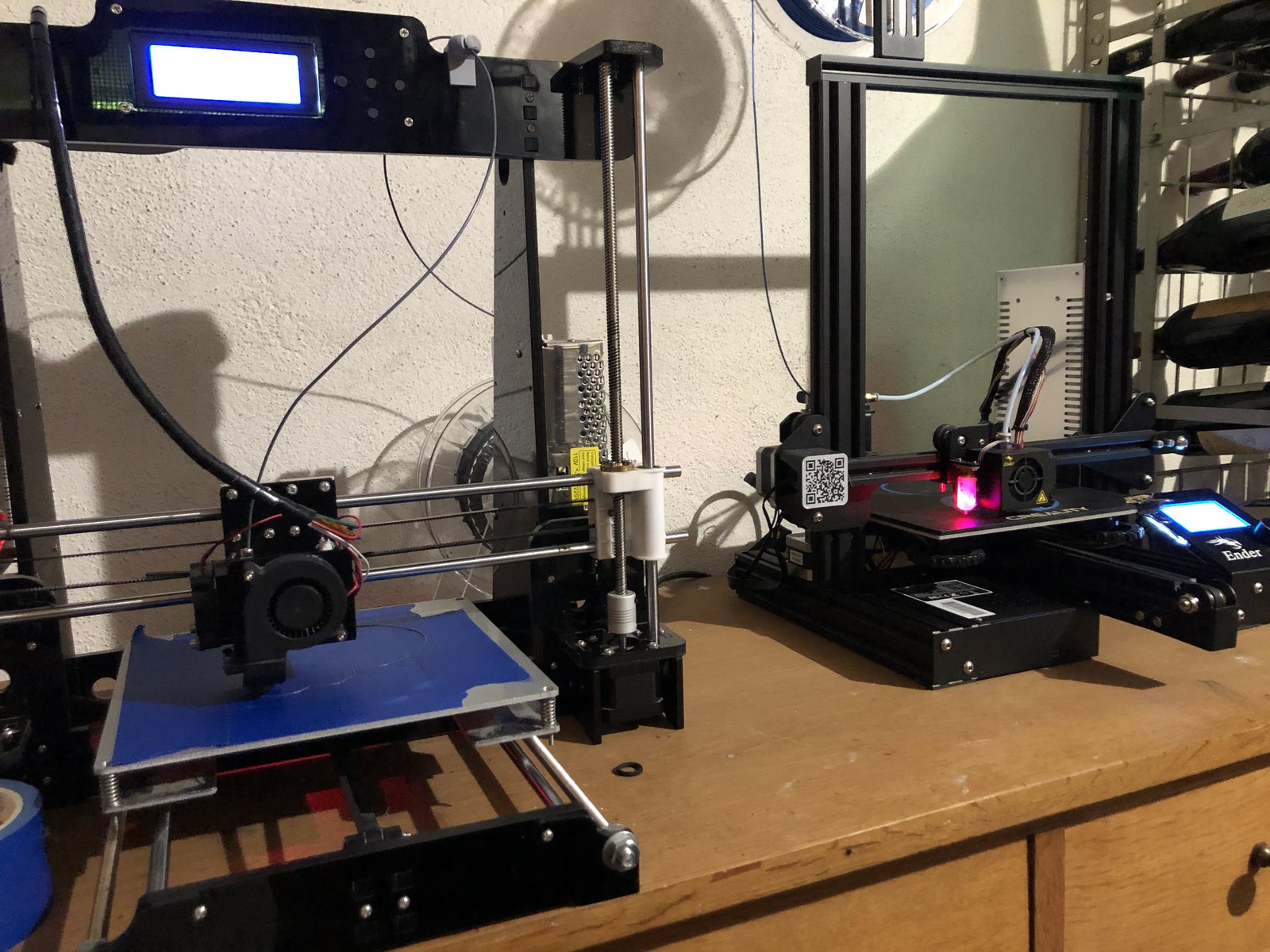Two 3D printers on a workshop bench